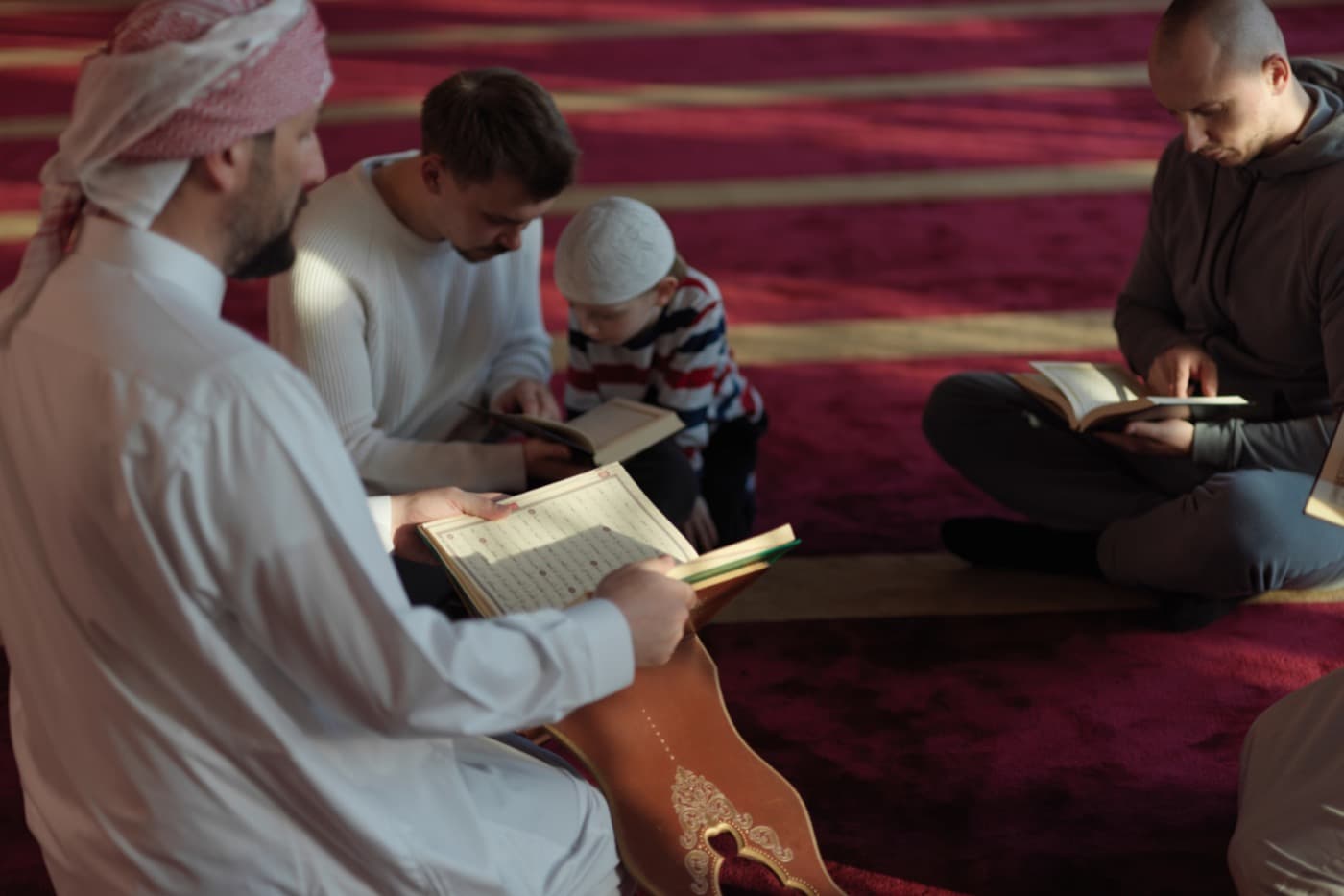 A male Quran teacher reading with students